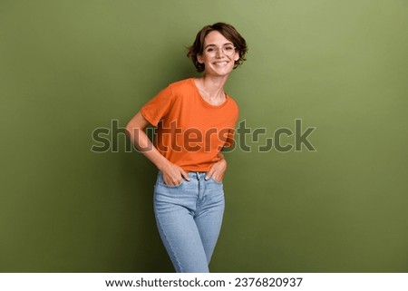 Portrait of positive cheerful person with short hair wear stylish t-shirt in eyewear arms in pockets isolated on green color background