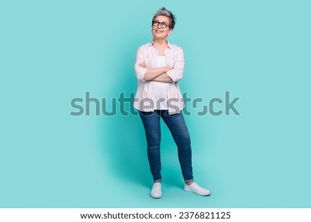 Photo of gorgeous lady marketer promoter wear trendy striped clothes interested looking empty space isolated on cyan color background