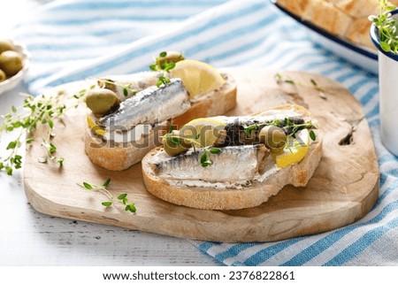 Sardines sandwiches on a white wooden background. Mediterranean food Royalty-Free Stock Photo #2376822861