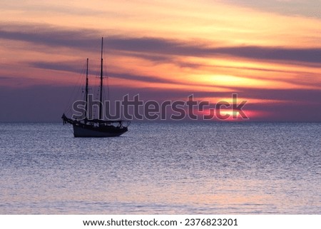 A sailing vessel is pictured against the stunning backdrop of a sunset near Koh Lanta, Thailand