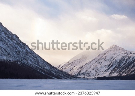 Snow-covered winter mountain lake, Russia, Siberia, Altai mountains. Multinskie lakes. Royalty-Free Stock Photo #2376825947