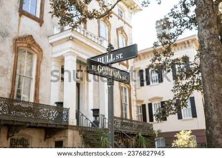 Ornate street sign in Savanah, Georgia, square in front of victorian home on warm summers day Royalty-Free Stock Photo #2376827945