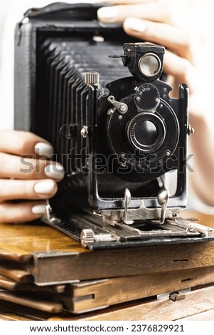 Women's hands operate an old camera.