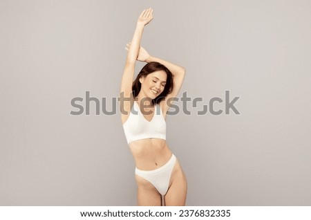Happy asian slim young woman in underwear, enjoy perfect soft skin, isolated on gray studio background. Body care, natural beauty, freshness and lifestyle, vitality, wellness Royalty-Free Stock Photo #2376832335