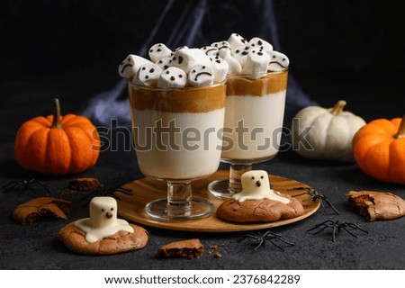 Halloween drink Dalgona coffee with marshmallows in glasses on a black background. Selective focus
