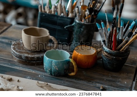 Handmade craft mugs in the pottery Royalty-Free Stock Photo #2376847841
