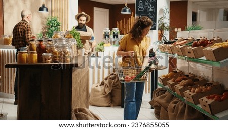 Bustling zero waste supermarket full of customers roaming around aisles looking for organic pantry staples. Local neighborhood shop where customers shop for fruits, vegetables, grains, spices, pasta Royalty-Free Stock Photo #2376855055