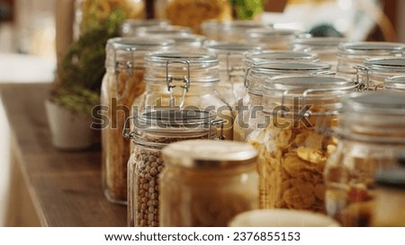 Close up on bulk products in recyclable glass containers used by zero waste supermarket to eliminate single use plastics. Local store pantry staples in sustainable packaging, zoom out shot Royalty-Free Stock Photo #2376855153