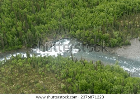 Lake Clark National Park in Alaska. Tanalian Falls and river. Aerial view of spruce trees, rugged mountains and popular day hike area near Port Alsworth and Hardenburg Bay. Royalty-Free Stock Photo #2376871223
