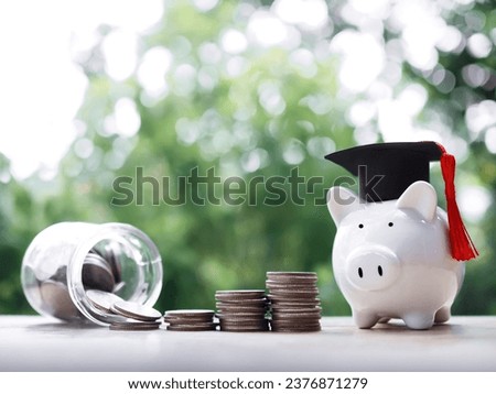 Piggy bank with graduation hat, Glass bottle and stack of coins. The concept of saving money for education, student loan, scholarship, tuition fees in future Royalty-Free Stock Photo #2376871279