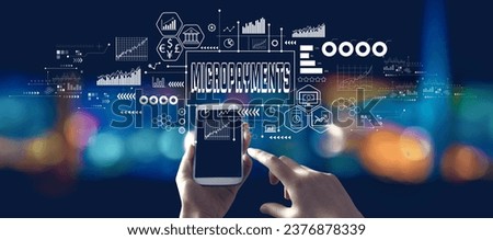 Micropayments theme with person using a smartphone in a city at night Royalty-Free Stock Photo #2376878339