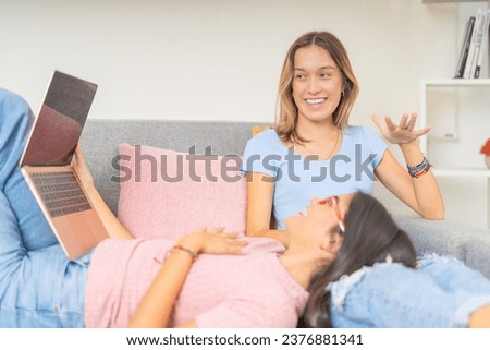 Horizontal photo of two happy students chilling out at home after studying together