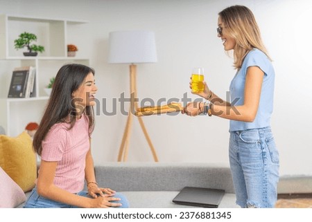Side view photo of a young woman offering pizza to her flat mate at home