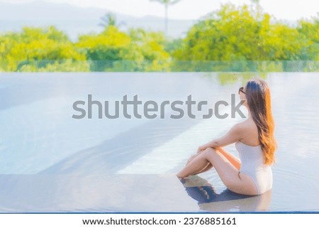 Portrait beautiful young asian woman enjoy around outdoor swimming pool with sea ocean view