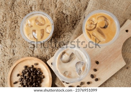 Delicious iced coffee, mocca, and chocolate drinks with coffee beans on white wooden table