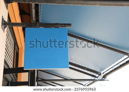 Square light box empty blue display on facade store wall outdoors shop facade mock up