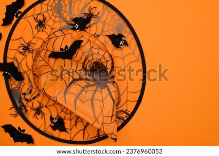 Orange Halloween hat with spiders,bats,ghosts on an orange background,top view. Halloween concept. Festival headdressss.