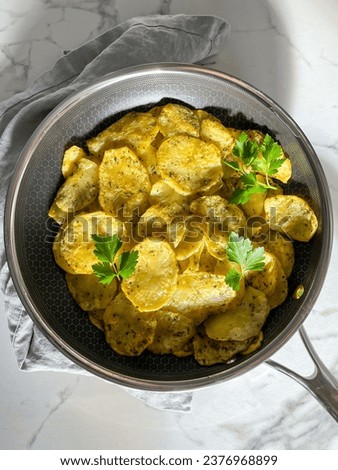 Pommes Anna, potato tart in a grey pan with white marble background, parsley, carbs, delicious food photography aerial potato pan picture
