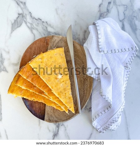Batsina with pumpkin, top view Greek traditional food closeup, thing pie slices on a wooden plate with marble white background