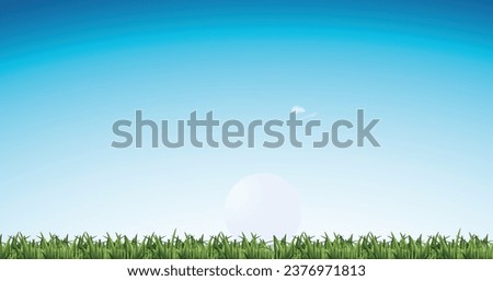 A vibrant golf ball resting on lush green grass under a clear blue sky