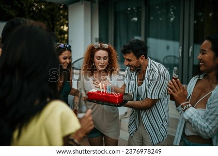A group of beaming friends comes together to commemorate a special birthday, the air filled with excitement and merriment