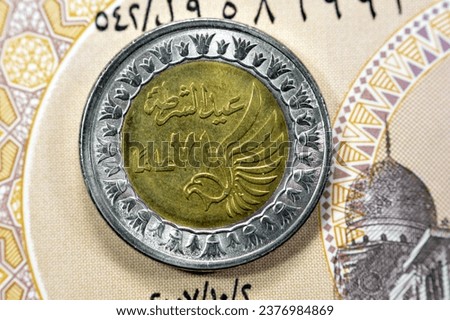 Obverse side of Egyptian 1 LE EGP One Egyptian pound coin on Egyptian banknote, Translation of Arabic (Police day 71 years) in the memorial of Egypt police day with a flying falcon
