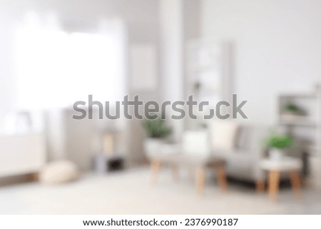 Blurred view of light living room with sofa and soft bench Royalty-Free Stock Photo #2376990187