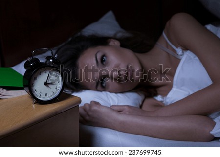 Woman with insomnia lying in bed with open eyes Royalty-Free Stock Photo #237699745