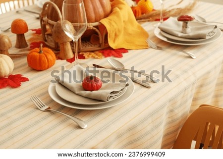 Festive table setting for Thanksgiving Day with pumpkin, napkin and cutlery, closeup