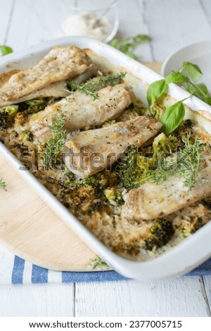 Baked fish with creamy brown rice and broccoli in a baking dish