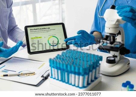 Two scientists working on a medical experiment in a laboratory, two doctors in protective clothing working and examining chemicals in a laboratory A team of researchers is working on a test tube.