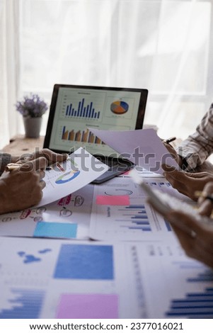 Analyzing business financial reports on laptop and laptop document graphs during corporate meeting discussion which shows successful teamwork Vertical close-up image