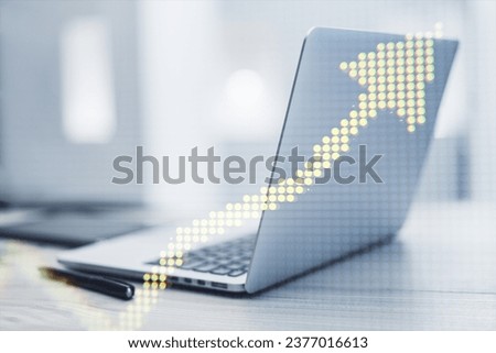 Close up of laptop computer at workplace with supplies and creative yellow pixel upward arrow on blurry background. Growth, success business and up concept. Double exposure