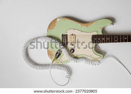 Old green guitar on white background. Vintage music poster. Grunge wallpaper