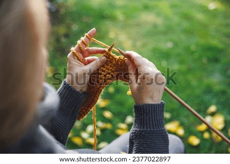 Woman knitting scarf with wool. Relaxation during craft hobby Royalty-Free Stock Photo #2377022897