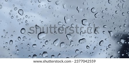 Image of rain falling against the window It is a picture of water drops and the picture outside the window is a hazy picture giving a feeling of sadness and loneliness.