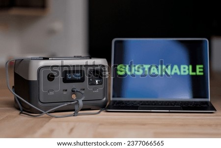An Uninterruptible Power Supply Source. Back-Up Option For The House During Black-Outs. Laptop With Sustainable Sign Charging With A Help Of Portable Power Supply Device