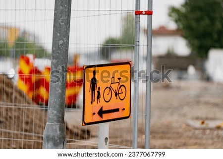 Pedestrian walking and bicycle sign on a fence