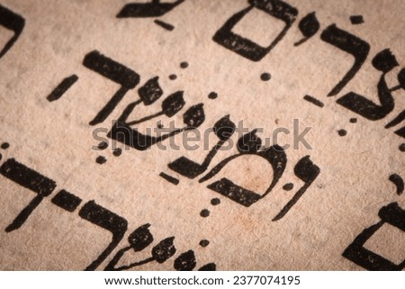 Hebrew word in Torah page. English translation is name Manasseh or Menashe. First son of Joseph ben Jacob and Asenath. Closeup. Selective focus Royalty-Free Stock Photo #2377074195