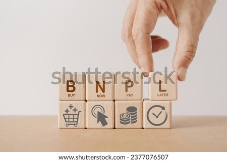 Hand arranged wooden cube blocks with  BNPL, alphabets abbreviation , and icon. For buy now pay later online shopping concept