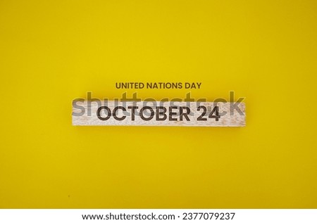 Wooden block with engraved sentence October 24 on a yellow background, World Polio Day. International Day for Climate Action. World Development Information Day. United Nations Day