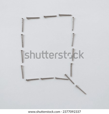 A bunch of nails. Letter shaped Q. White background