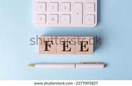 FEE on a wooden cubes with pen and calculator, financial concept