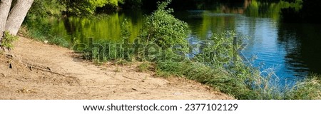 Panorama view scenic river bank with sandy shore, lush green trees and calm water along Trinity River near Dallas, Texas, America. Scenery waterfront landscape Royalty-Free Stock Photo #2377102129