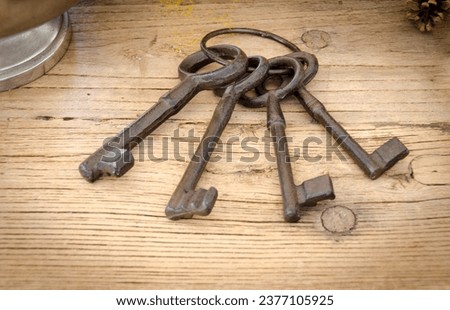Rusty antique keys on wooden table as background Royalty-Free Stock Photo #2377105925