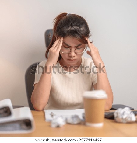 Asian woman having Tired and Stressed while working, female businesswoman having headache and Migraine at office, Exhausted woman with document folder stack at home late night. Overworked and Overtime