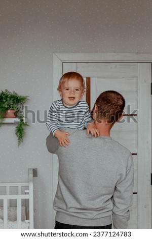 Baby boy in the arms of happy father at home. High quality photo