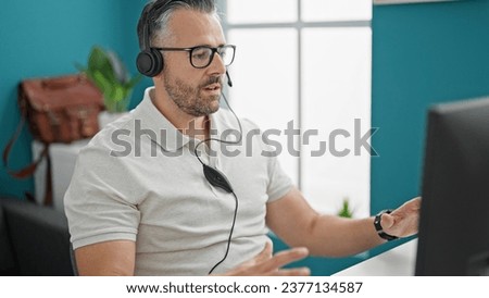 Grey-haired man business worker having video call at the office