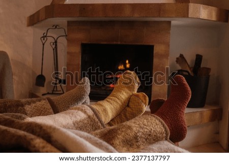 Winter socks next to a wood-burning fireplace to combat the cold. Concept: winter, cold days, shelter Royalty-Free Stock Photo #2377137797