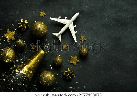 Christmas concept background. Champagne bottle,christmas balls,sparkling glitter and plane with space for text on gray background. Christmas travel concept
